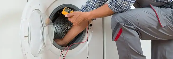 Dryer repair technician inspecting and repairing a clothes dryer in Scottsdale, AZ