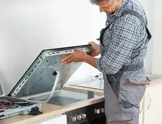 Appliance repair technician installing a built-in cooktop in Scottsdale, AZ