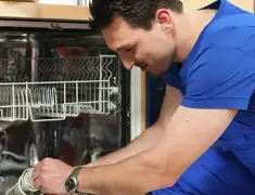 Dishwasher repair technician inspecting and servicing an open dishwasher in Scottsdale, AZ
