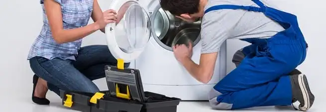 Washer repair technician inspecting a front-load washing machine with tools in Scottsdale, AZ