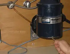 Garbage disposal repair technician tightening the mounting ring under a sink in Scottsdale, AZ