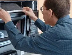 Appliance repair technician replacing a microwave vent filter in Scottsdale, AZ