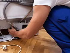 Appliance repair technician fixing refrigerator water line and connections in Scottsdale, AZ