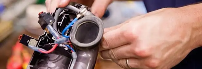 Vacuum repair technician reconnecting wiring and components in Scottsdale, AZ