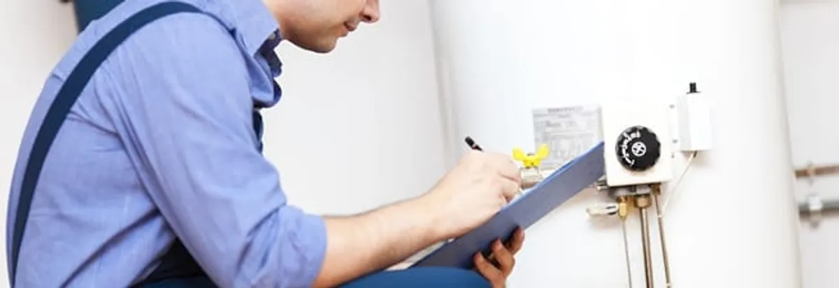 Water heater repair technician inspecting the unit and recording service notes in Scottsdale, AZ