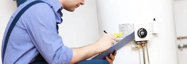 Water heater repair technician inspecting the unit and recording service notes in Scottsdale, AZ