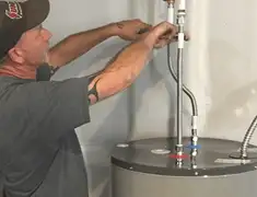 Water heater repair technician tightening supply line connections in Scottsdale, AZ