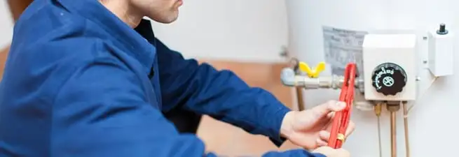 Water heater repair technician adjusting the temperature control and gas valve in Scottsdale, AZ